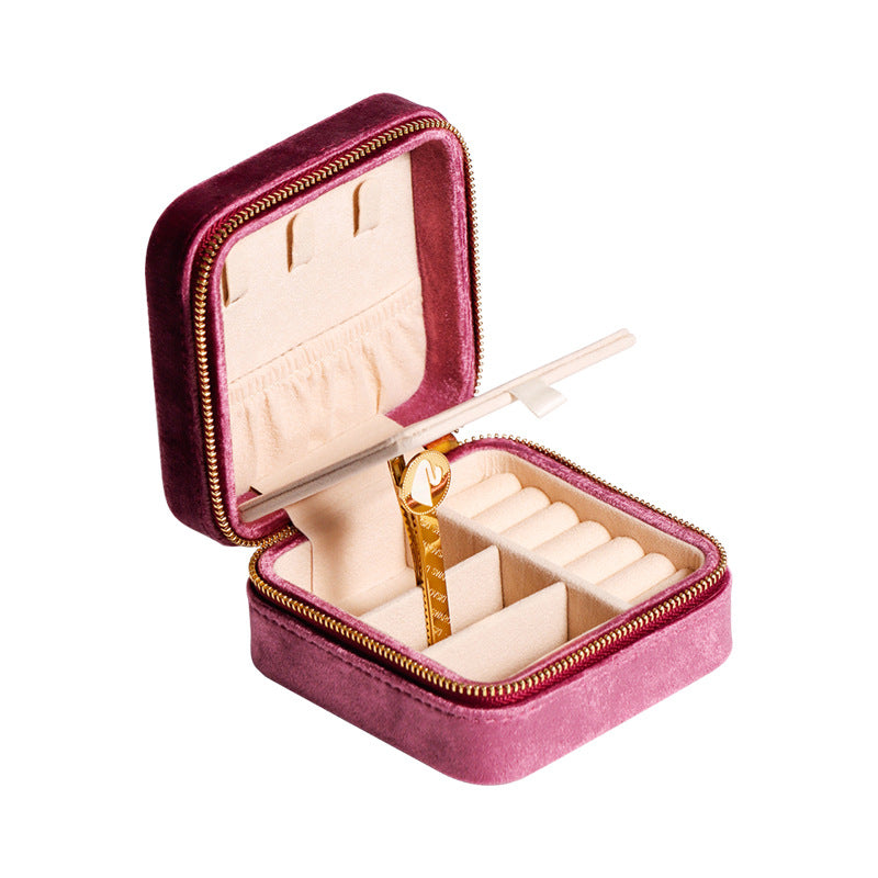 Open pink velvet travel jewellery box with ring rolls and earring slots