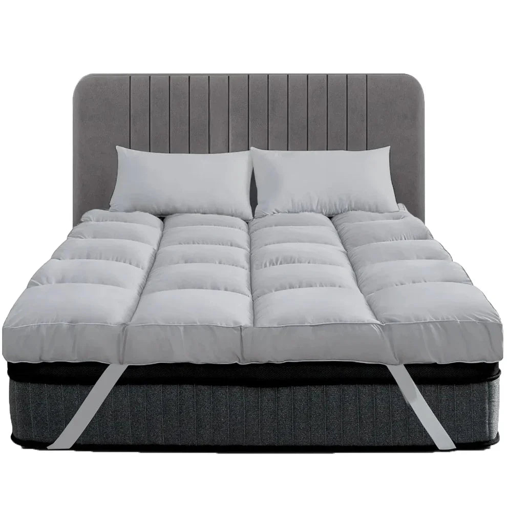 Grey 10cm thick mattress topper with corner straps on a bed